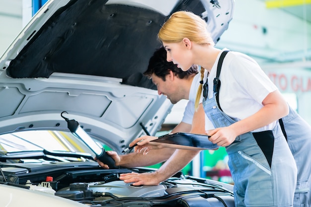 Foto equipo mecánico trabajando en taller automotriz.