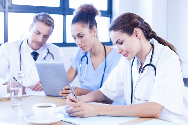 Equipo médico discutiendo en reunión en una sala de conferencias