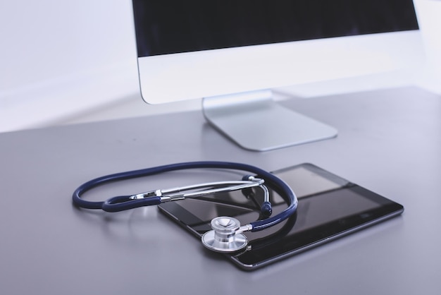 Equipo médico estetoscopio azul y tableta sobre fondo blanco equipo médico