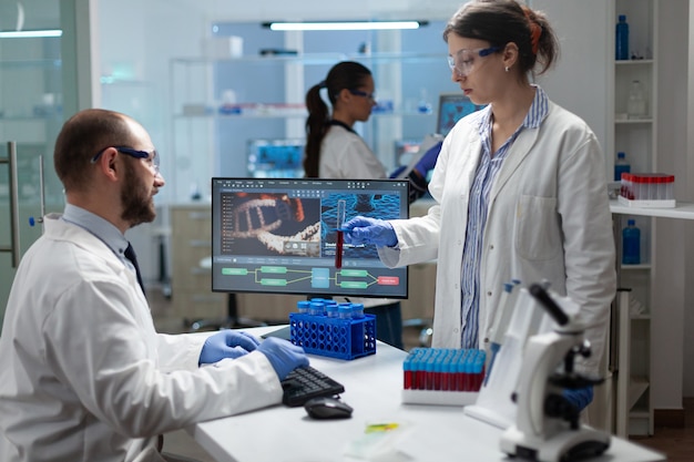 Equipo médico examinando la muestra de sangre discutiendo la experiencia en virus