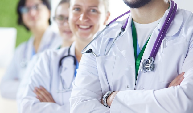 Equipo médico feliz compuesto por médicos masculinos y femeninos sonriendo ampliamente y dando un pulgar hacia arriba del éxito y la esperanza