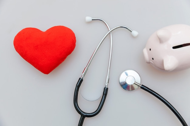 Equipo médico de medicina estetoscopio o fonendoscopio hucha y corazón rojo aislado en blanco