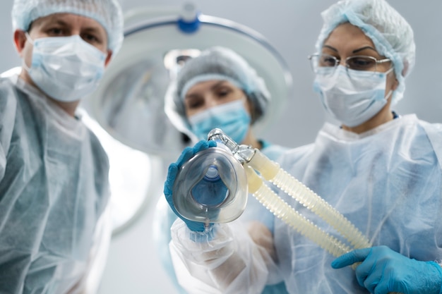 Equipo médico poniendo máscara de oxígeno al paciente