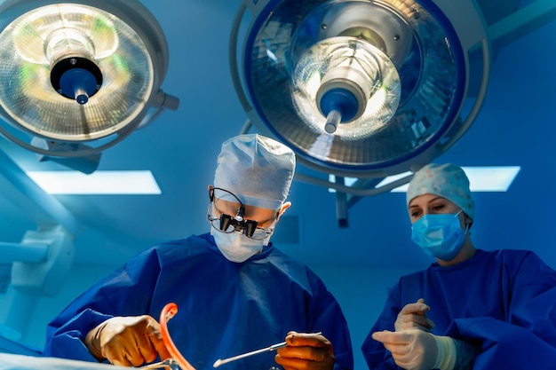 Foto equipo médico que realiza la operación quirúrgica en la sala de operaciones moderna