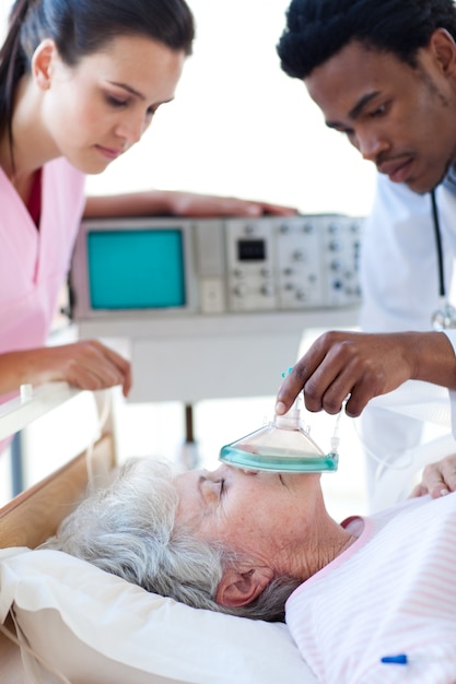 Equipo médico resucitando a un paciente mayor