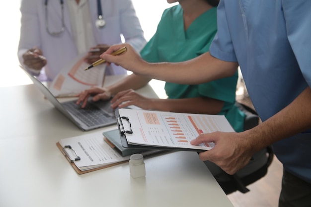 Equipo médico reunido alrededor de la mesa en un hospital moderno