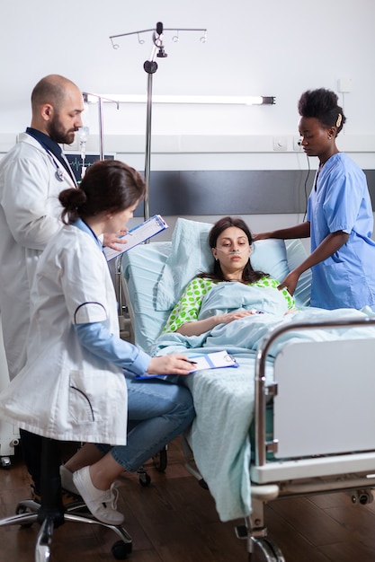 Equipo médico de seguimiento del paciente enfermo durante la cita de recuperación en la sala del hospital