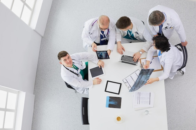 Equipo médico sentado y discutiendo en la mesa, vista superior