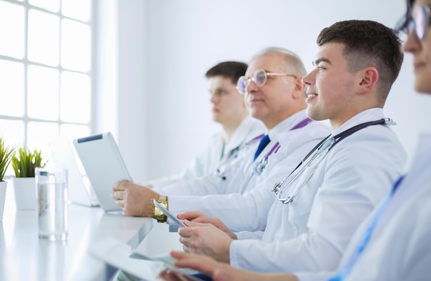 Equipo médico sentado y discutiendo en la mesa