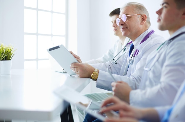 Equipo médico sentado y discutiendo en la mesa