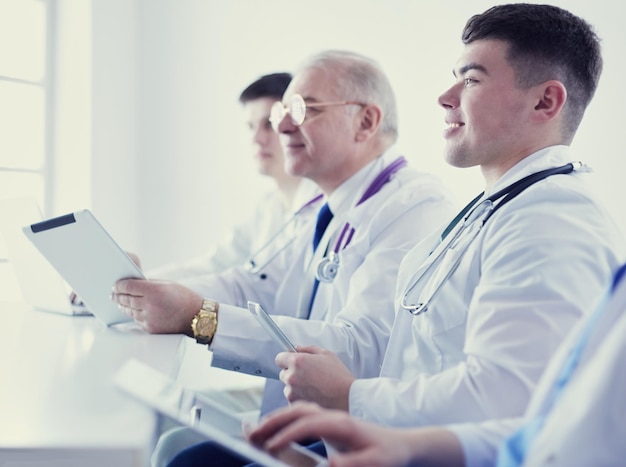 Equipo médico sentado y discutiendo en la mesa