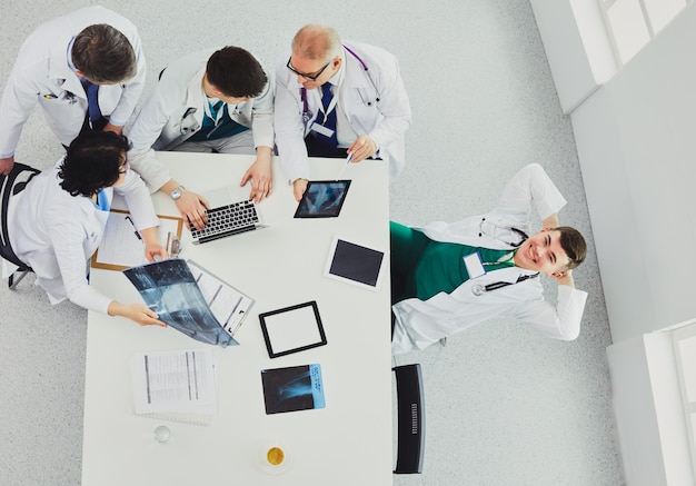 Equipo médico sentado y discutiendo en la vista superior de la mesa