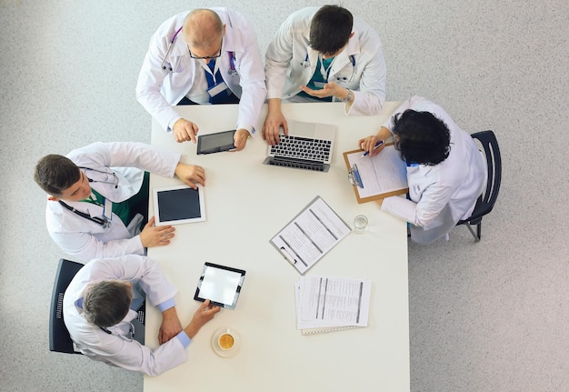 Equipo médico sentado y discutiendo en la vista superior de la mesa