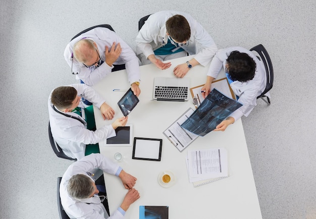 Equipo médico sentado y discutiendo en la vista superior de la mesa