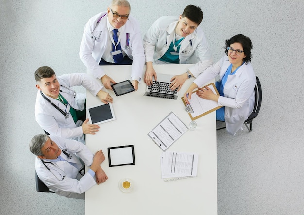 Equipo médico sentado y discutiendo en la vista superior de la mesa