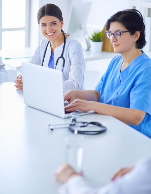 Equipo médico serio discutiendo el caso del paciente en una oficina luminosa