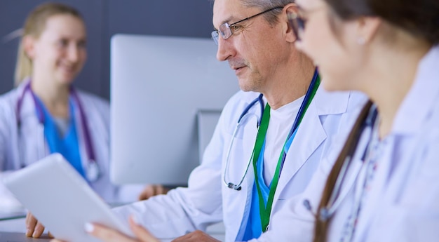 Equipo médico serio usando una computadora portátil en una oficina luminosa