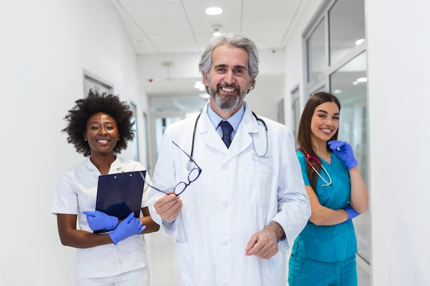 Equipo médico sonriente de pie juntos en un hospital, profesión