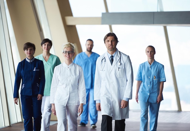 equipo de médicos caminando en el pasillo del hospital moderno en el interior, grupo de personas