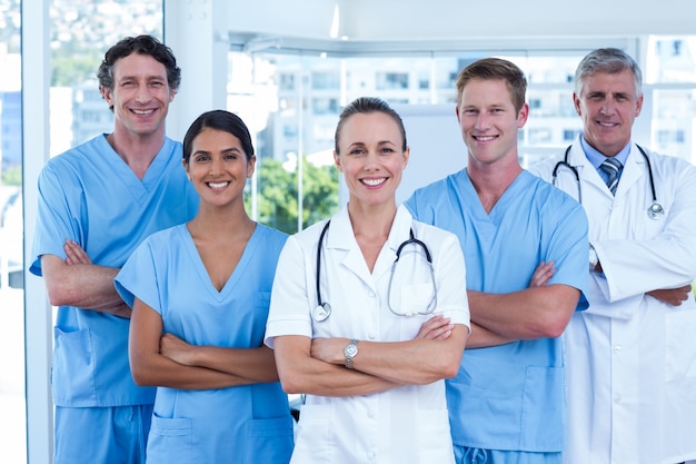 Equipo de médicos de pie brazos cruzados y sonriendo a la cámara