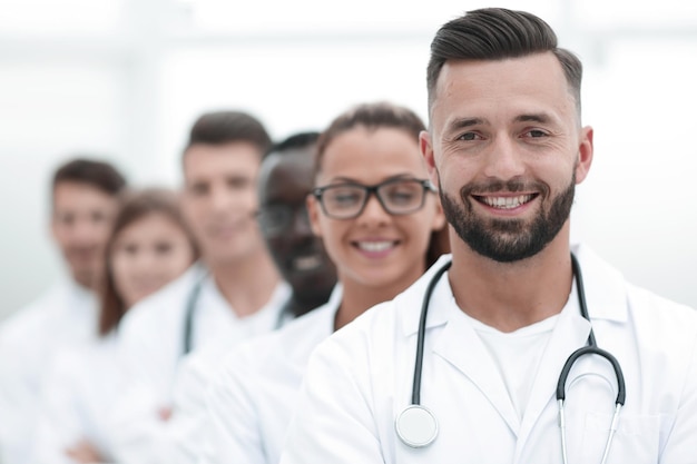 Equipo de médicos profesionales jóvenes de pie juntos en el laboratorio posando con los brazos cruzados