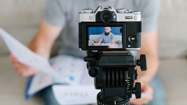 Equipo moderno para el hombre de filmación de video que usa una cámara en un trípode para la creación de imágenes herramientas útiles para el concepto de blogs