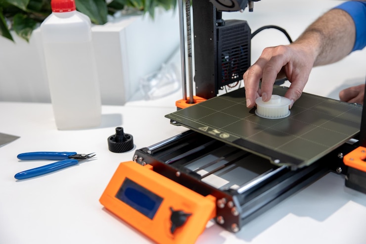 Foto equipo moderno de impresora 3d y hombre que trabaja con él en la oficina