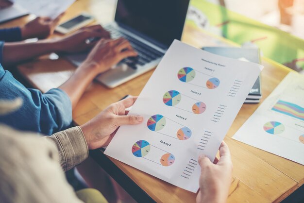 Foto equipo mujer de negocios manos trabajando y sosteniendo diagrama de información gráfica de negocios