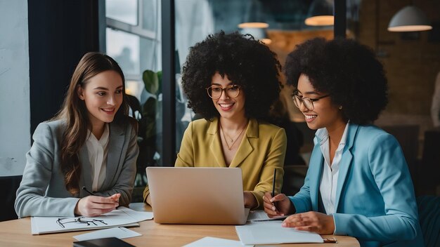 Equipo de mujeres empresarias que cooperan mientras trabajan en la computadora portátil durante una reunión de negocios