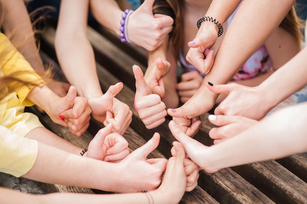 Equipo de mujeres jóvenes sentadas juntas y cogidas de la mano