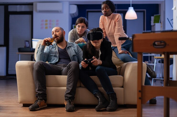 Foto equipo multiétnico de compañeros juegan con gafas vr después del trabajo en la fiesta de la oficina. diversos grupos de amigos disfrutan de la experiencia de juego con el joystick del controlador de la consola para celebrar la victoria
