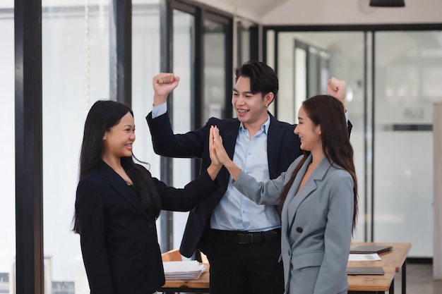 Un equipo de negocios alegre y feliz celebrando el nuevo logro juntos.