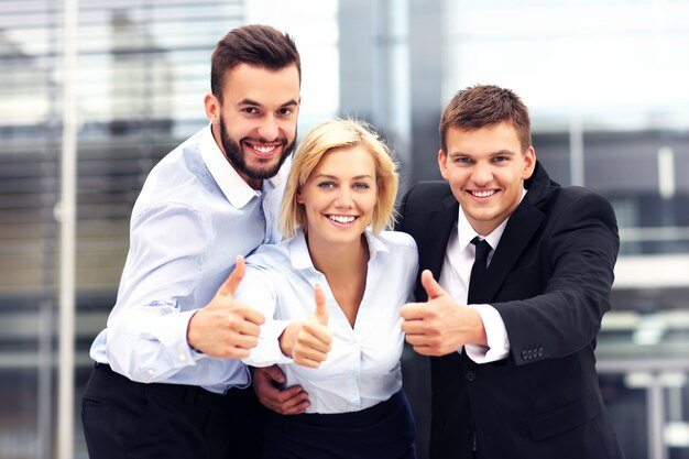 Foto un equipo de negocios alegre fuera del edificio moderno