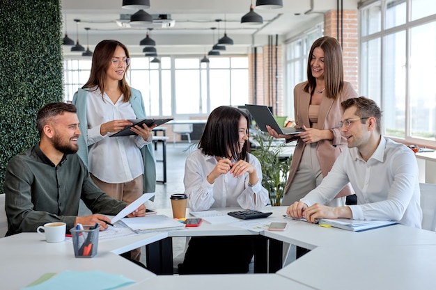 Equipo de negocios amigable alegre discutiendo estrategias de planes de negocios en la oficina