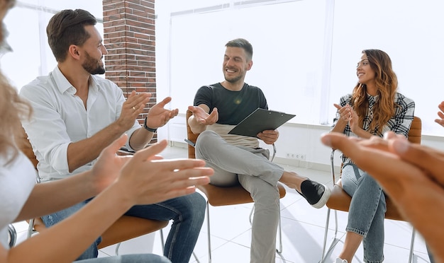 Foto equipo de negocios aplaudiendo a su gerente de proyecto