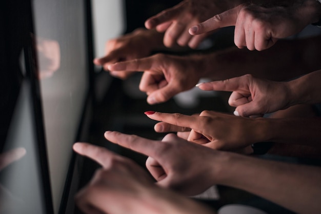 Equipo de negocios apuntando con el dedo a la foto de la pantalla de la computadora con espacio de copia