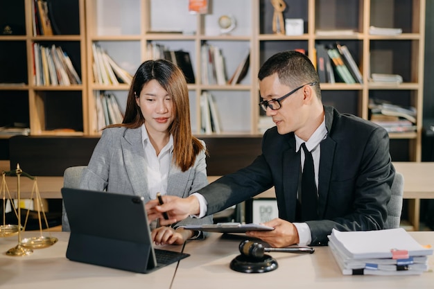 Foto equipo de negocios asiáticos y abogados discutiendo documentos contractuales sentados en la mesa conceptos de asesoramiento legal servicios legales en la oficina