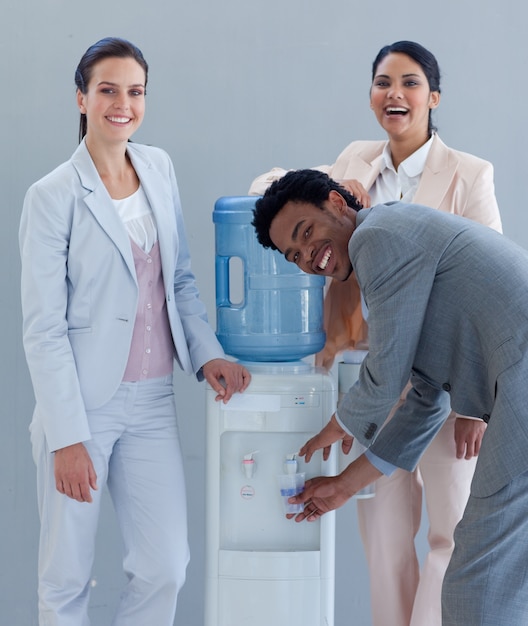 Equipo de negocios bebiendo de un enfriador de agua