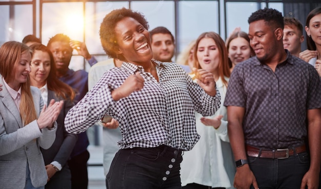 Equipo de negocios celebrando un triunfo con los brazos arriba.