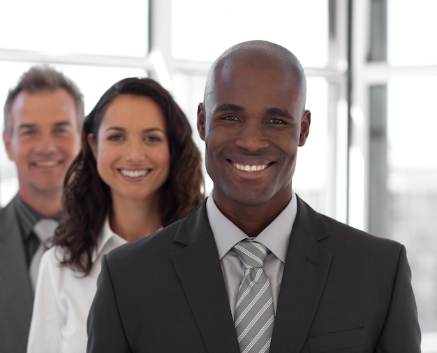 Equipo de negocios de cinco personas mirando a la cámara y sonriendo