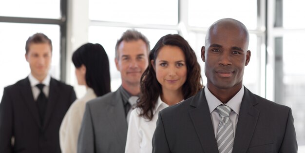 Equipo de negocios de cinco personas mirando a la cámara y sonriendo