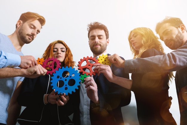 Foto el equipo de negocios conecta piezas de engranajes como trabajo en equipo y socio