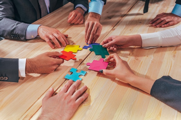 El equipo de negocios conecta piezas de rompecabezas como un trabajo en equipo y socios
