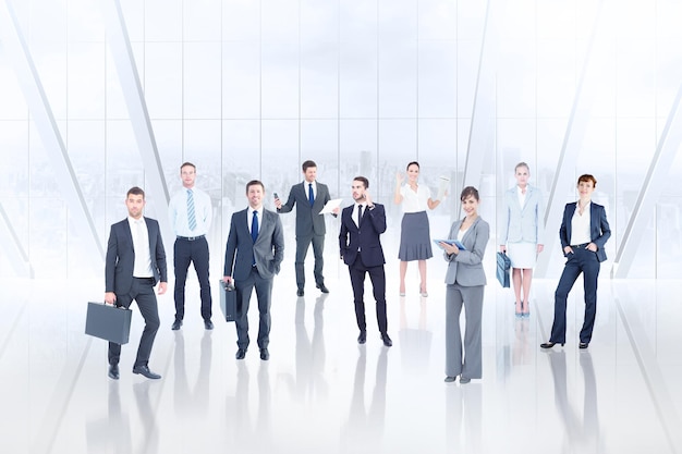 Equipo de negocios contra sala blanca con ventana grande con vista a la ciudad