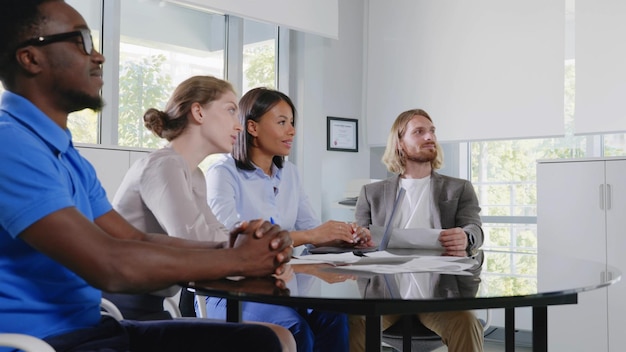 Equipo de negocios corporativos sentado en la sala de reuniones escuchando al líder