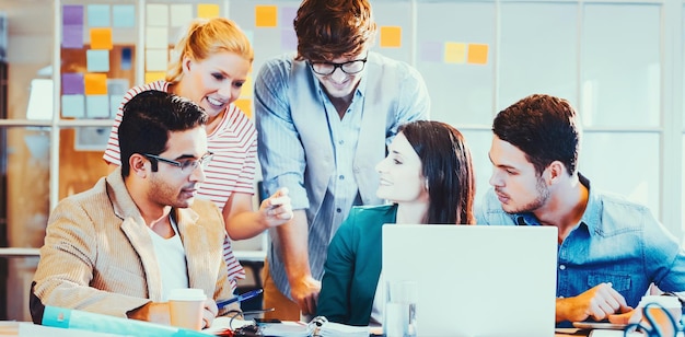 Equipo de negocios creativo feliz que usa una computadora portátil en una reunión en la oficina