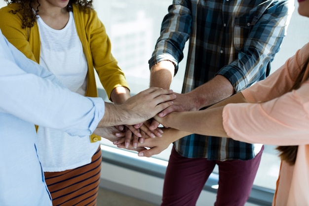 Equipo de negocios creativos apilando las manos juntas en la oficina