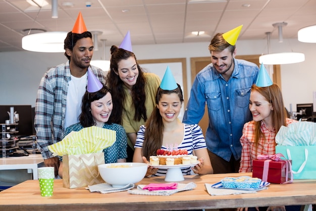 Equipo de negocios creativos celebrando el cumpleaños de colegas en la oficina