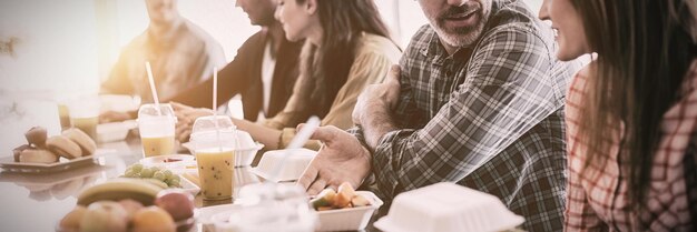 Equipo de negocios creativos discutiendo mientras come