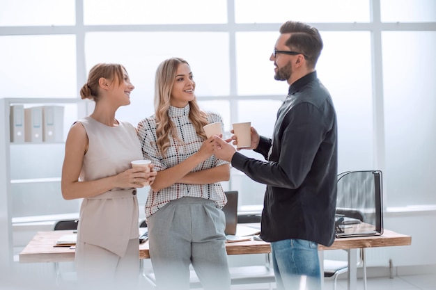 Foto equipo de negocios discutiendo algo de pie en la oficina